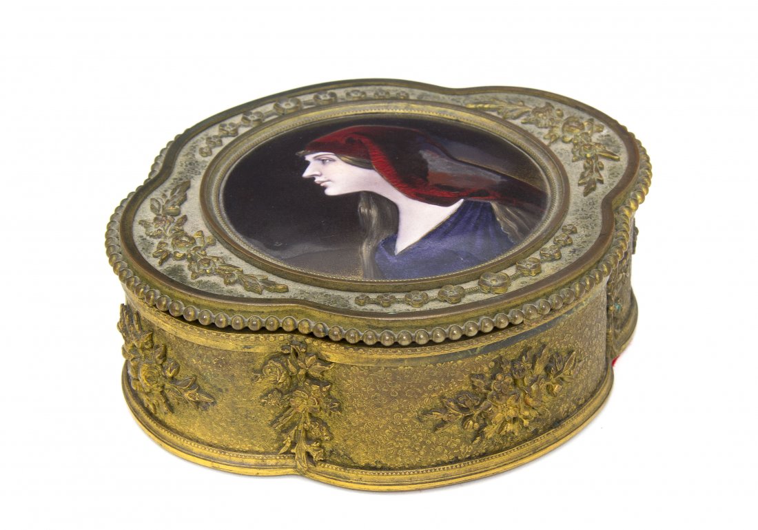 A French Enameled Copper Inset Gilt Metal Box, Widt: A French Enameled Copper Inset Gilt Metal Box, the round medallion depicting Saint Fabiola, signed Leroux, the round medallion set within the cartouche form lid, over the conforming body. Width 5 1/2 