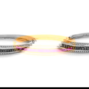 RUBY AND DIAMOND BANGLE BRACELET: RUBY AND DIAMOND BANGLE BRACELET Containing round brilliant cut diamonds and channel set rubies, hinged with side clasp. Mounted in 18 karat bicolor gold. 6 1/2 inches inner circumference. Stamp: 750