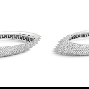 WHITE GOLD AND DIAMOND BANGLE BRACELET: WHITE GOLD AND DIAMOND BANGLE BRACELET Containing numerous round brilliant cut diamonds weighing approximately 6.00 carats total, hinged with side clasp. Mounted in 18 karat white gold. 6 1/2 inches i
