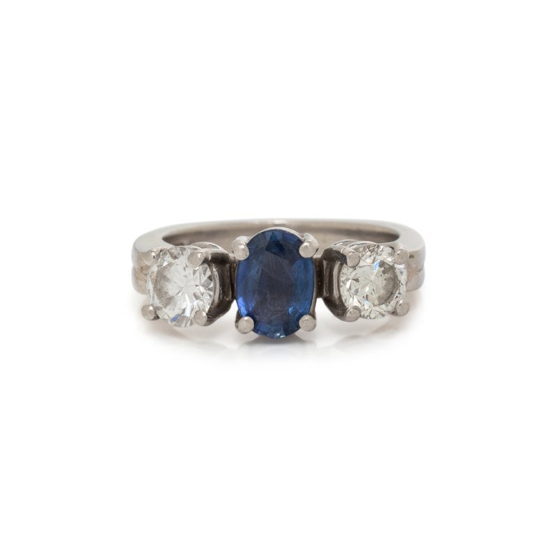 SAPPHIRE AND DIAMOND RING: SAPPHIRE AND DIAMOND RING One oval mixed cut sapphire measuring approximately 6.97 x 4.75 mm and two round brilliant cut diamonds weighing approximately 0.90 carat total. Platinum and 18 karat white g
