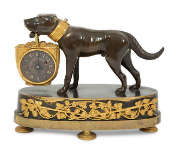 A Small French Gilt and Patinated Bronze Dog Clock: A Small French Gilt and Patinated Bronze Dog Clock Mid 19th Century of a dog carrying a grape filled basket containing a French movement. Height 5 3/8 x width 6 5/8 x depth 2 7/8 inches. This lot is l