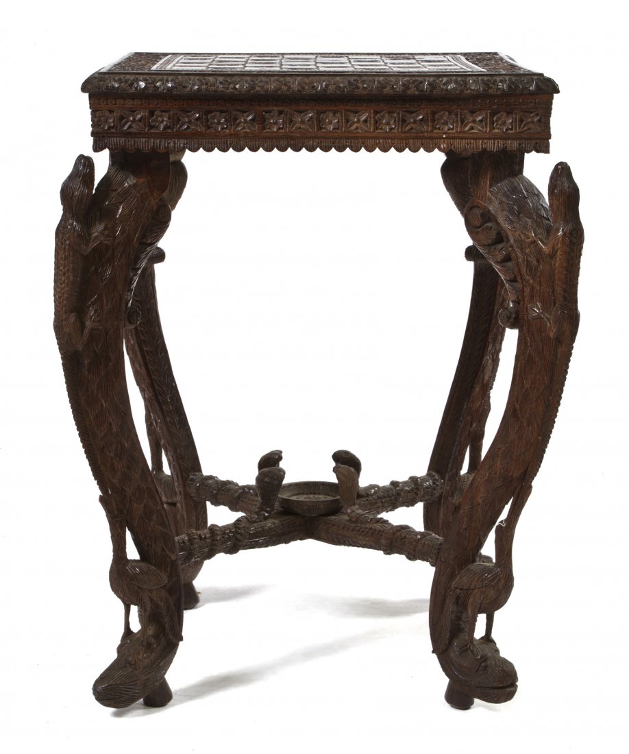 An Anglo-Indian Carved Hardwood Games Table, Heig: An Anglo-Indian Carved Hardwood Games Table, the square top with incised chessboard, within the scrolling foliate border, raised on lizard and bird carved cabriole legs joined by a cobra carved X-form