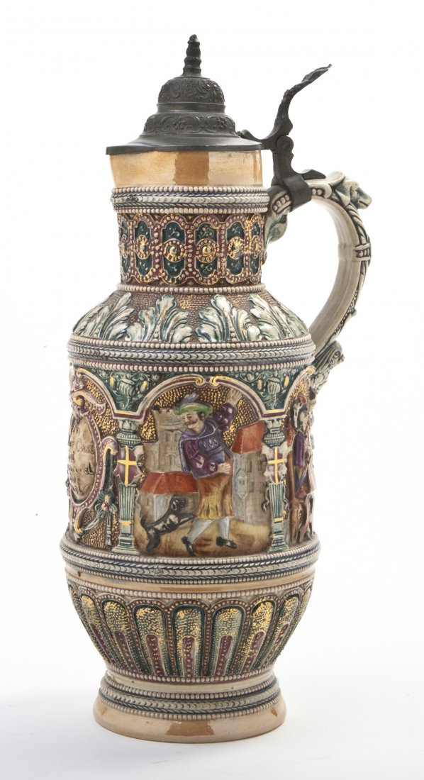 A German Pottery Stein, Diesinger, Height 13 1/2 : A German Pottery Stein, Diesinger, with raised decoration of figures drinking in an interior setting, having a pewter mounted lid and thumb press, marked DRMG. Height 13 1/2 inches. Property from the 
