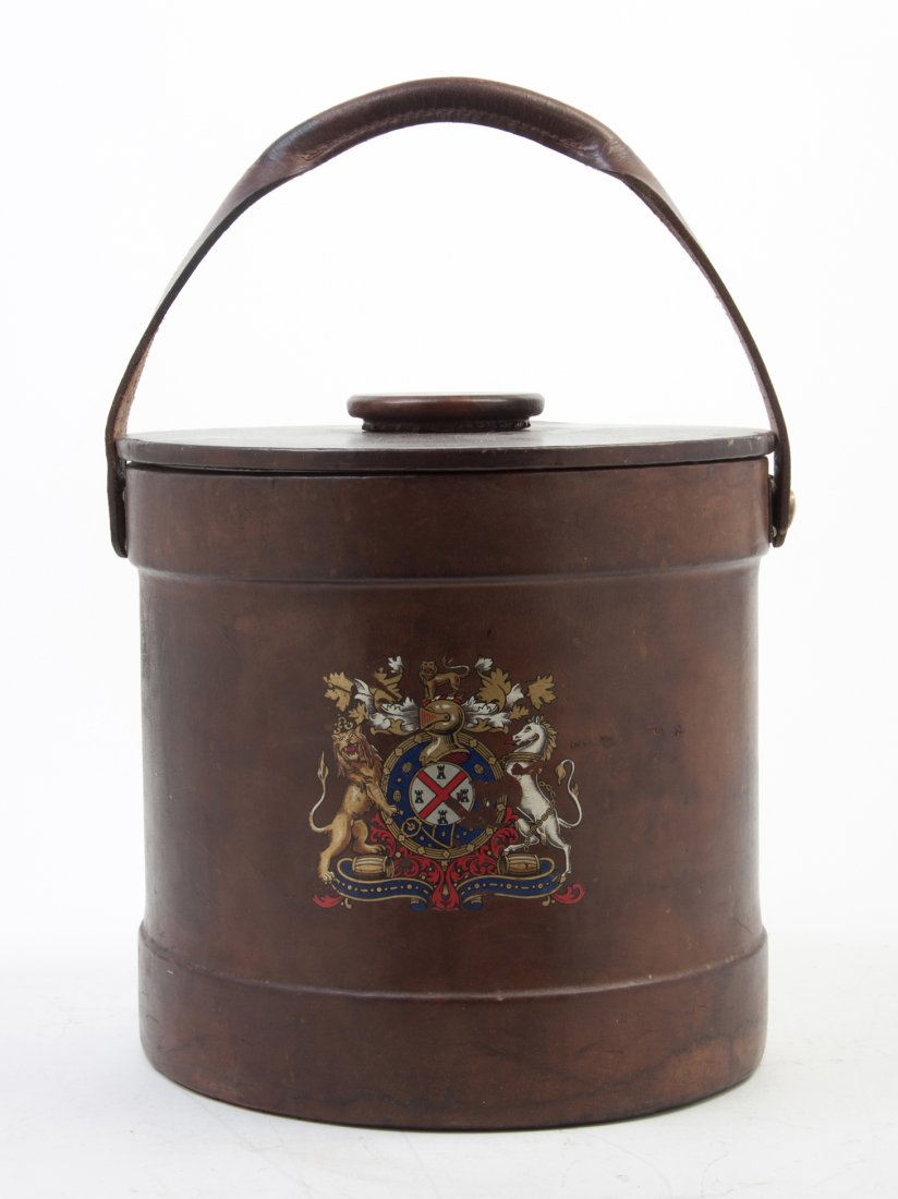 An English Leather Clad Ice Bucket, Height 12 3/4: An English Leather Clad Ice Bucket, of cylindrical form having a swing handle and crest decoration. Height 12 3/4 inches. Property from the Estate of Helen and C. Nicholas Johnson, Jr., Cave Creek, Ar