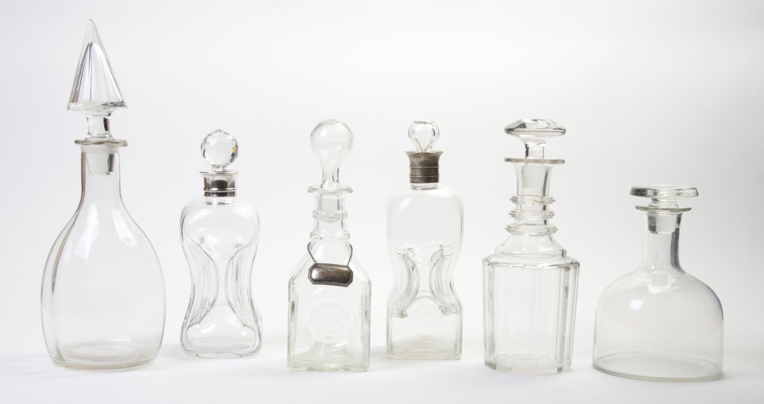 A Group of Six Glass Decanters, Height of tallest: A Group of Six Glass Decanters, of various forms, two having English silver mounts, one having a liquor tag. Height of tallest 10 1/2 inches. Property from the Estate of Helen and C. Nicholas Johnson,