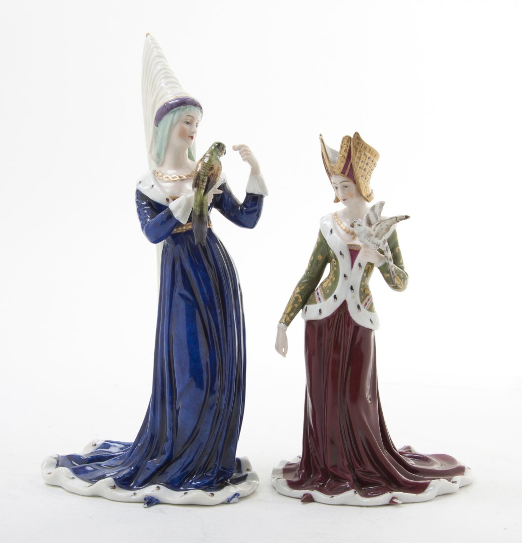 Two Continental Porcelain Figures, Height of tall: Two Continental Porcelain Figures, each depicting a lady in Medieval attire holding a bird, having various marks. Height of tallest 9 1/2 inches. Property from the Collection of Mr. and Mrs. Allen M.