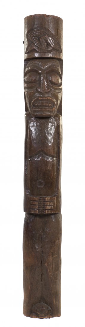 A Carved Wood Tiki Totem, Height 76 inches.: A Carved Wood Tiki Totem, of cylindrical form, depicting a stylized figure with clasped hands, bared teeth and a headdress. Height 76 inches. Property from Trader Vic's, Chicago, Illinois
