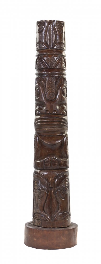 A Carved Wood Tiki Totem, Height 58 inches.: A Carved Wood Tiki Totem, of tapering cylindrical form, depicting multiple stylized figures, raised on a circular base. Height 58 inches. Property from Trader Vic's, Chicago, Illinois