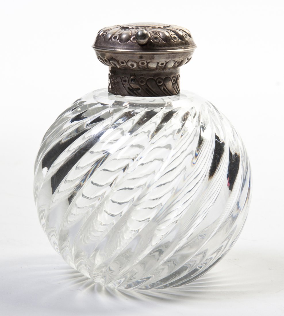 A Silver Mounted Glass Perfume Bottle, Height 5 1: A Silver Mounted Glass Perfume Bottle, the silver cap having chased radial design and English hallmarks, the silver collar having conforming decoration and English and Russian hallmarks. Height 5 1/4 
