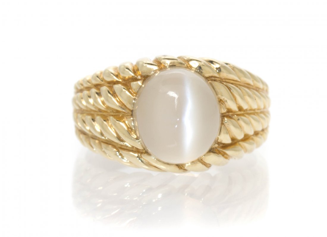 A 14 Karat Yellow Gold and Cat's Eye Moonstone Rin: A 14 Karat Yellow Gold and Cat's Eye Moonstone Ring, in a rope texture design setting, containing one oval cabochon cut cat's eye moonstone measuring approximately 10.67 x 9.65 x 7.58 mm. Stamp: 14K P