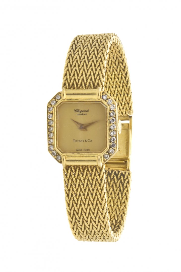An 18 Karat Yellow Gold and Diamond Watch, Chopard: An 18 Karat Yellow Gold and Diamond Watch, Chopard for Tiffany & Co., 20.00 x 18.75 mm case dimensions, matte gold dial signed CHOPARD GENEVE TIFFANY & CO., yellow gold dauphine hands, bezel contains