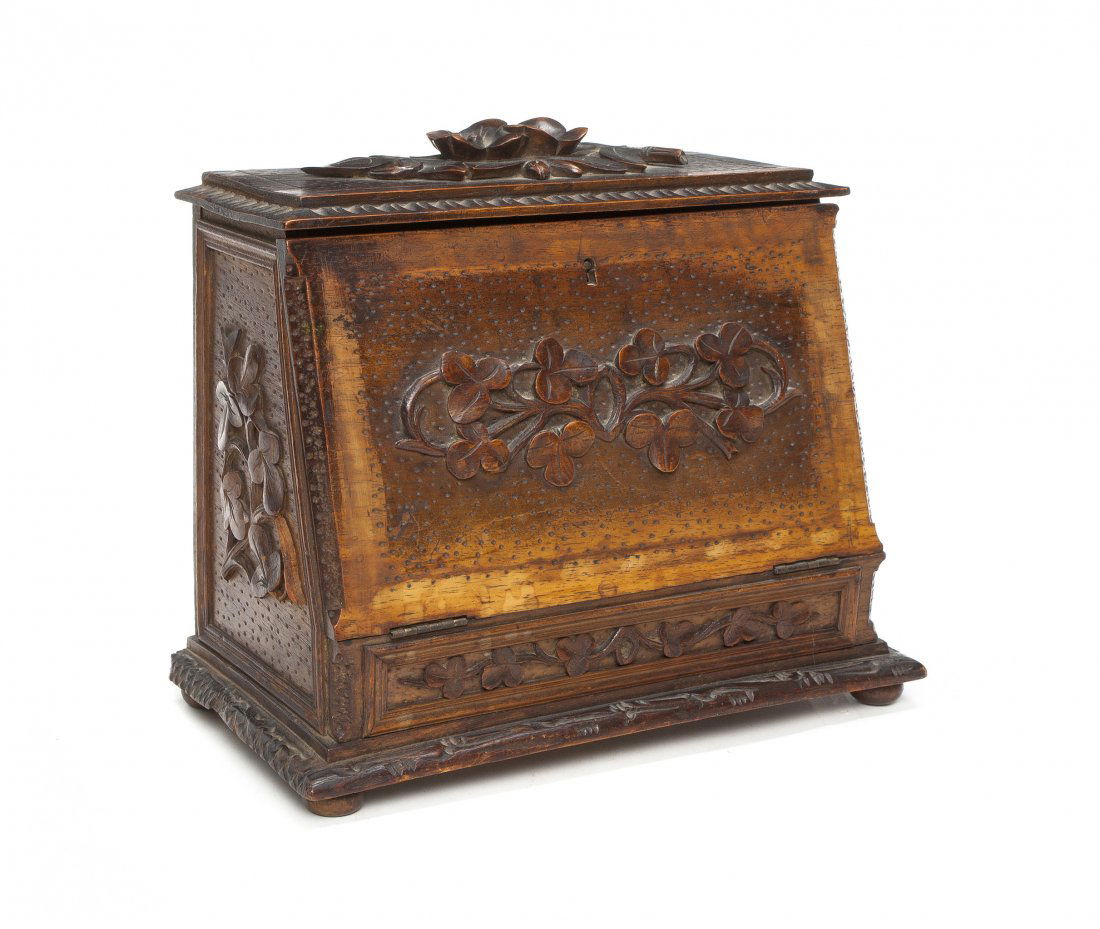 An English Carved Walnut Letter Box, Height 8 1/2 i: An English Carved Walnut Letter Box, having a rectangular lift-top and drop-front with foliate carved decoration, over a conforming base, raised on flattened ball feet. Height 8 1/2 inches.