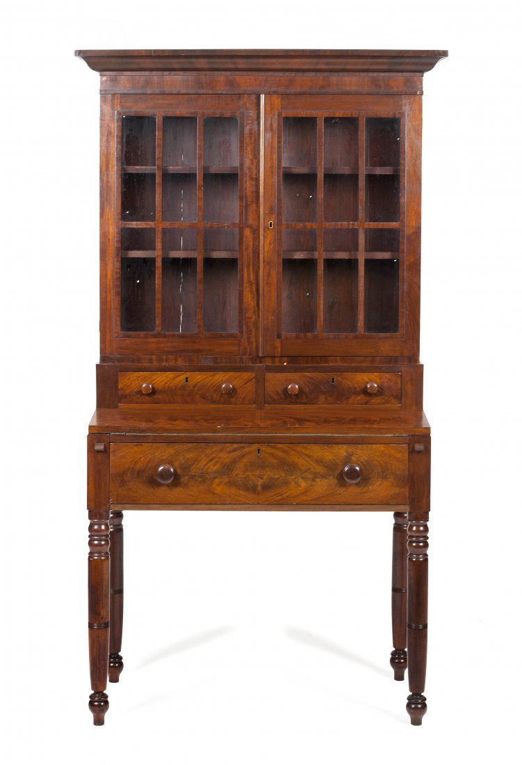 An American Mahogany Secretary Writing Desk, Heigh: An American Mahogany Secretary Writing Desk, having a molded cornice over two glazed paneled doors, above two short drawers, over fold out writing surface, above a single long drawer, raised on turned