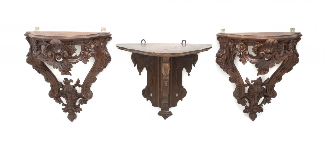 A Pair of Continental Carved Walnut Wall Brackets,: A Pair of Continental Carved Walnut Wall Brackets, each with pierced Rococo decoration throughout, together with an associated oak example. Height of pair 16 inches.
