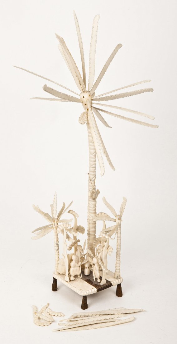 An African Carved Ivory Diorama, Height 25 1/2 inc: An African Carved Ivory Diorama, depicting a meeting of figures below towering palm trees. Height 25 1/2 inches.
