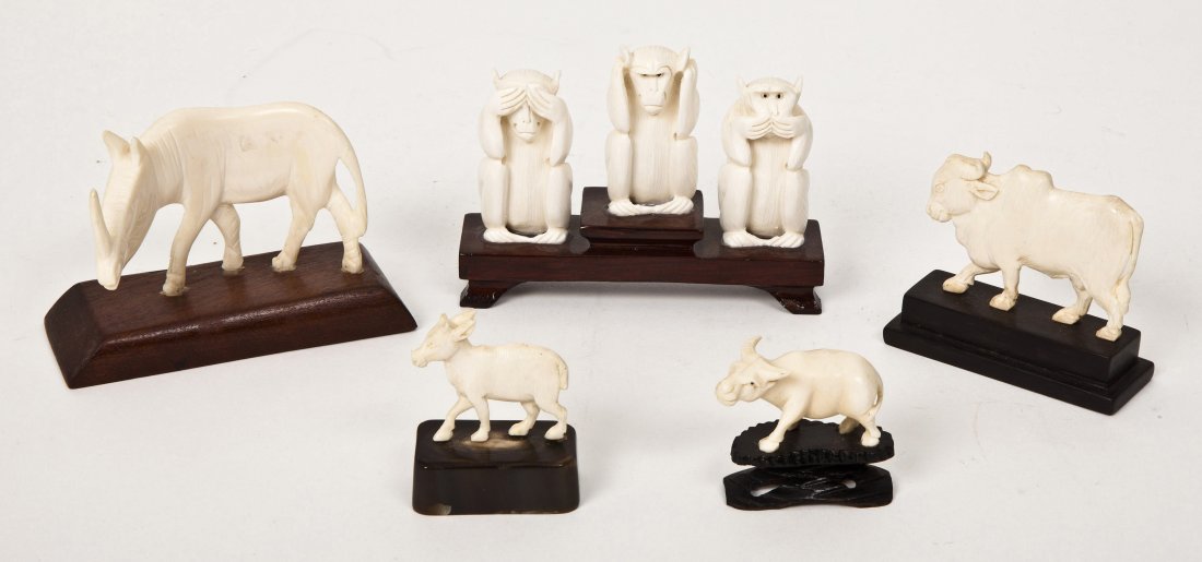 An Ivory Carving of Three Monkeys, Height of talle: An Ivory Carving of Three Monkeys, mounted on a wooden stand, depicting 'See no evil, hear no evil, speak no evil', together with a rhinoceros, two bulls and a donkey. Height of tallest 3 1/4 inches.