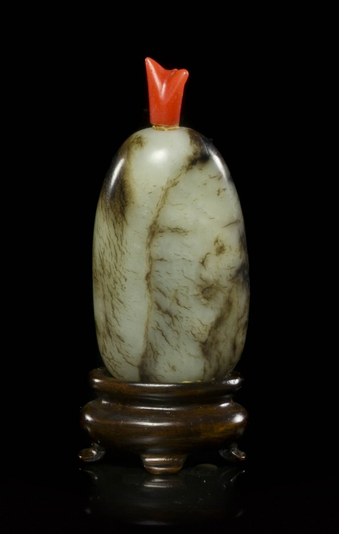 A Pebble Form Jade Snuff Bottle, Height overall 2 7/: A Pebble Form Jade Snuff Bottle, of celadon colored stone having russet veining throughout, with a carved coral stopper. Height overall 2 7/8 inches. Property from the Collection of Jean F. Schmidt, C