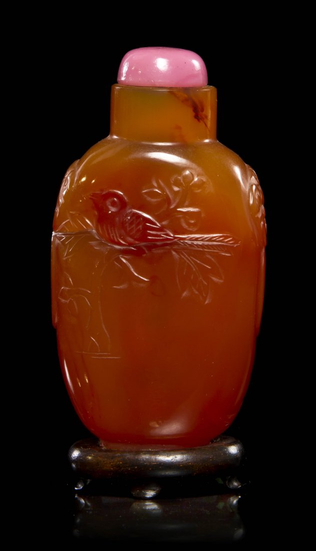 A Carnelian Snuff Bottle, Height 2 3/4 inches.: A Carnelian Snuff Bottle, with relief carved decoration of birds on flowering branches, flanked by animal mask and faux ring handles. Height 2 3/4 inches.