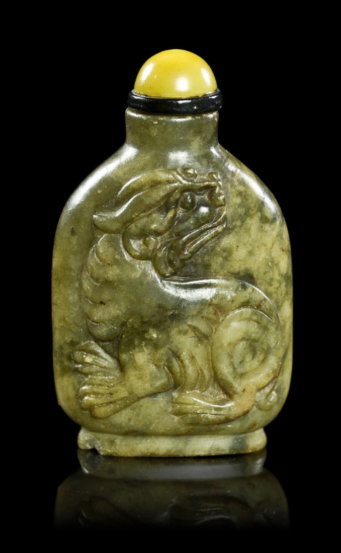 A Carved Soapstone or Steatite Snuff Bottle, Height: A Carved Soapstone or Steatite Snuff Bottle, of rounded rectangular form of green and brown colored stone, having carving in relief of a qilin, the reverse having an incised archaistic inscription in 