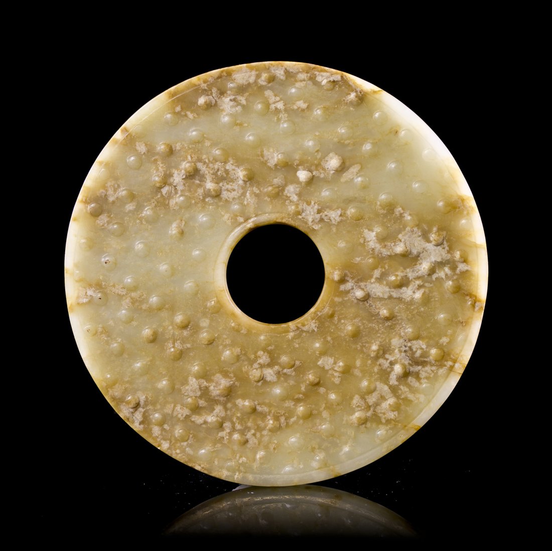 A Chinese Jade Bi, Diameter 5 3/8 inches.: A Chinese Jade Bi, Warring States Period or later, of semi-translucent, pale celadon and brown colored stone, having raised bosses throughout the surface on both sides. Diameter 5 3/8 inches. Provenan