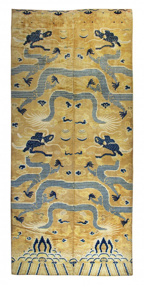 A Chinese Wool Carpet, 18 feet 4 inches x 8 feet 8: A Chinese Wool Carpet, Qing Dynasty, of rectangular form depicting four five-clawed dragons of blue color atop a yellow/pale orange reserve with scrolling clouds, flames and embroidered orbs above cra