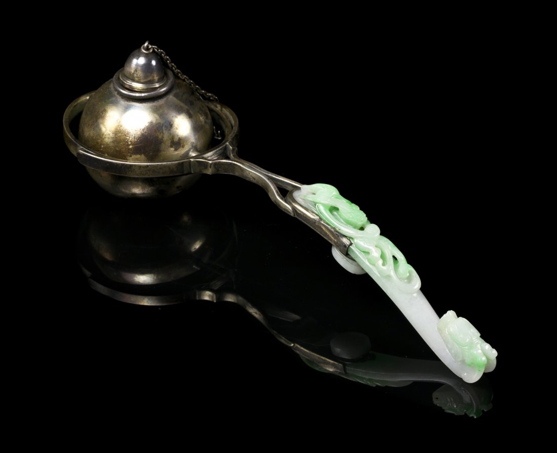 A Jadeite Belthook and Silver Mounted Cigar Lighte: A Jadeite Belthook and Silver Mounted Cigar Lighter, the hook of apple green and white colored stone with a sinuous qilong on the back, mounted with a spherical silver ball and stamped S&G Gump Co. St
