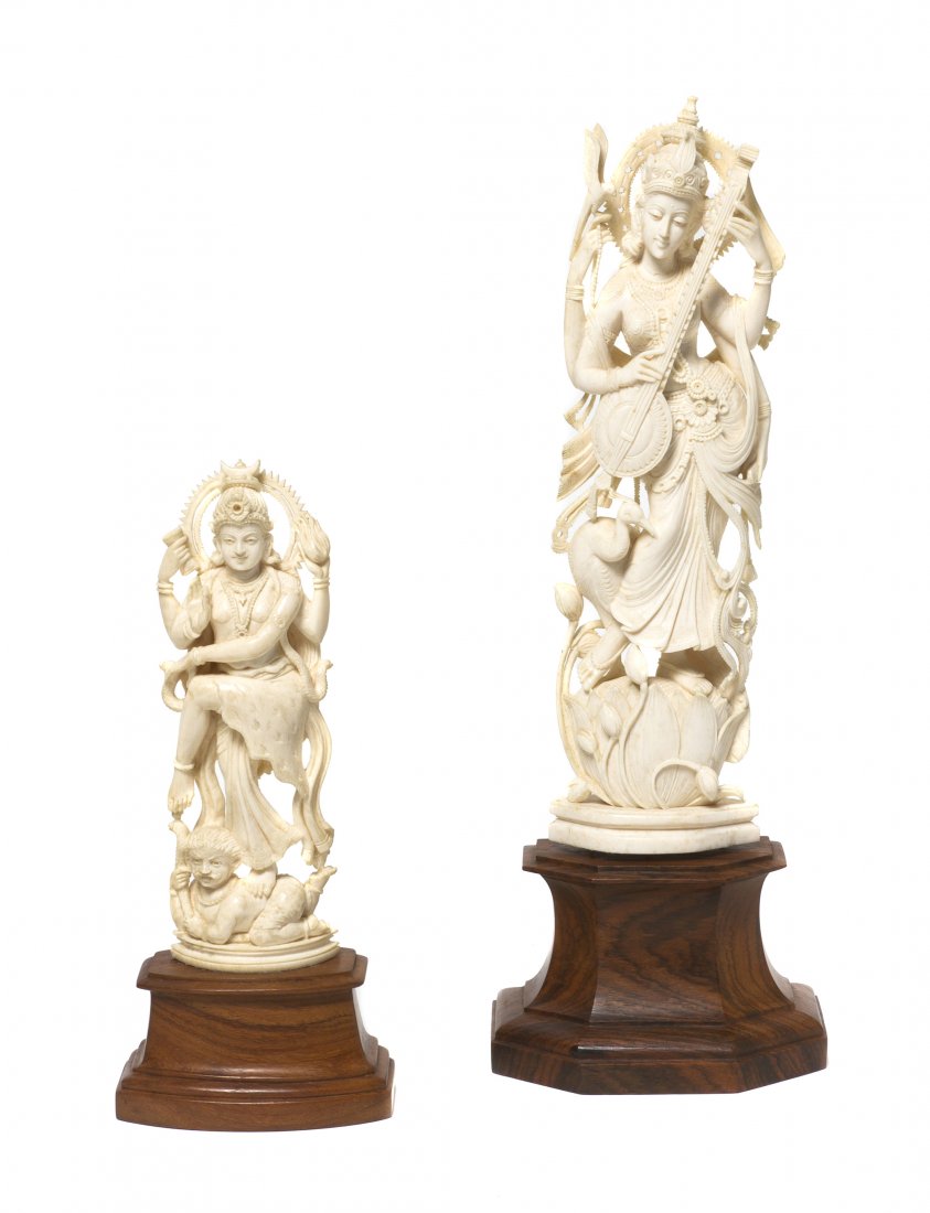 Two Indian Carved Ivory Figures of Deities, Height: Two Indian Carved Ivory Figures of Deities, each shown in a standing pose with intricate carving and raised atop faceted hardwood bases. Height of taller 9 inches.