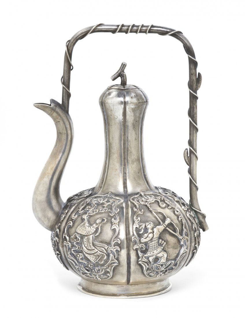 A Japanese Silver Teapot, Height 7 1/8 inches.: A Japanese Silver Teapot, of lobed gourd form, having raised decoration on the body of figures in shaped cartouches, having arched handle with applied scrolling tendril decoration, raised upon a flare