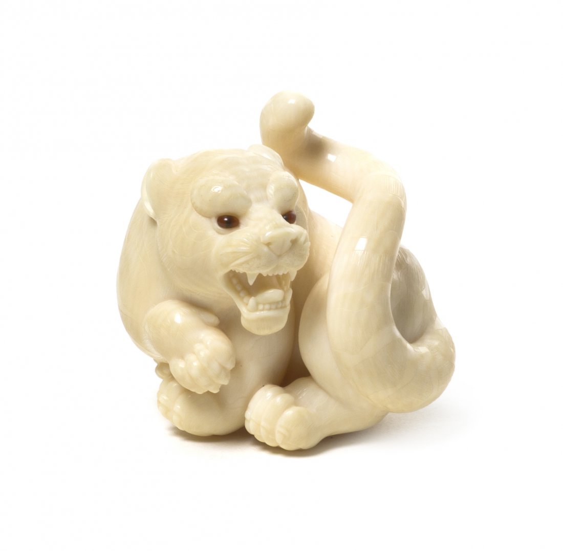 A Carved Ivory Tiger Netsuke, Kangyoku Rishisai, H: A Carved Ivory Tiger Netsuke, Kangyoku Rishisai, 20th century, having inlaid eyes, with signature and signature cartouche incised to the underside, with original wood box. Height 1 5/8 inches. Propert