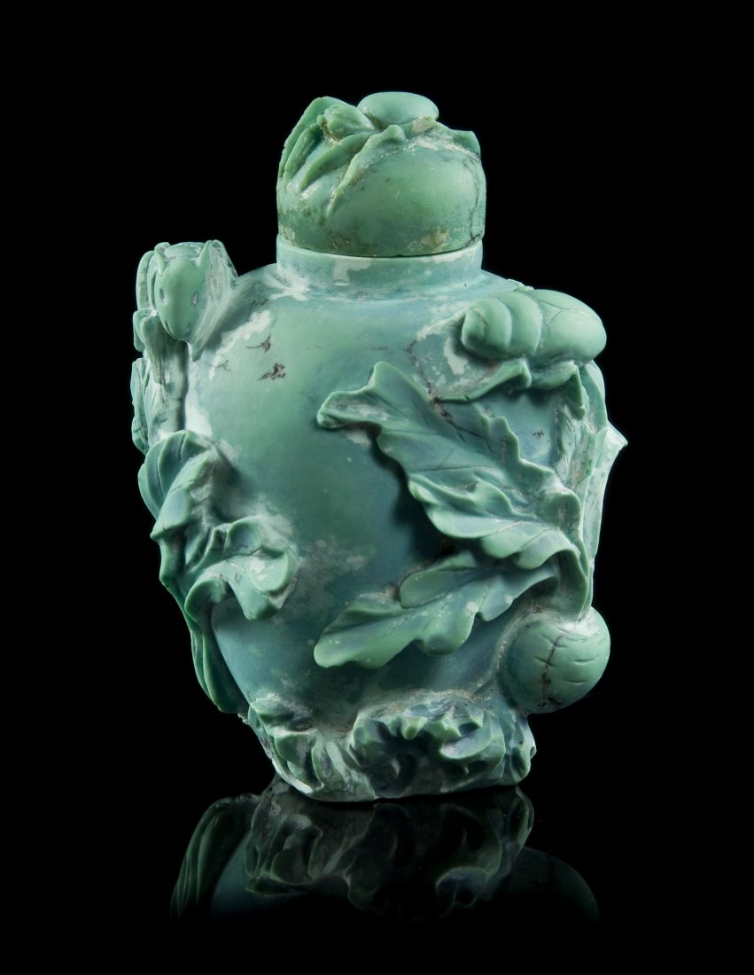A Carved Turquoise Snuff Bottle, Height overall 2: A Carved Turquoise Snuff Bottle, having lotus blossoms, beetles and foliate carving throughout. Height overall 2 1/4 inches.