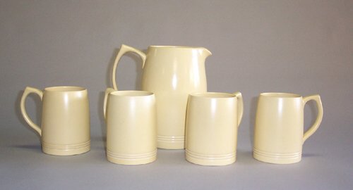 KEITH MURRAY FOR WEDGWOOD CIDER SET Glaz: KEITH MURRAY FOR WEDGWOOD CIDER SET Glazed ceramic; ink & stamped marks, 5 pieces, pitcher h: 8 in., mugs h: 4 3/4 in.