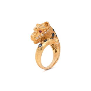 YELLOW GOLD, DIAMOND AND MULTIGEM LEOPARD RING: YELLOW GOLD, DIAMOND AND MULTIGEM LEOPARD RING In a by-pass design, with round brilliant cut diamonds, round mixed cut sapphire spots and ruby eyes. Ring size 8 1/4. Stamp: 750. Gross weight: 12.20