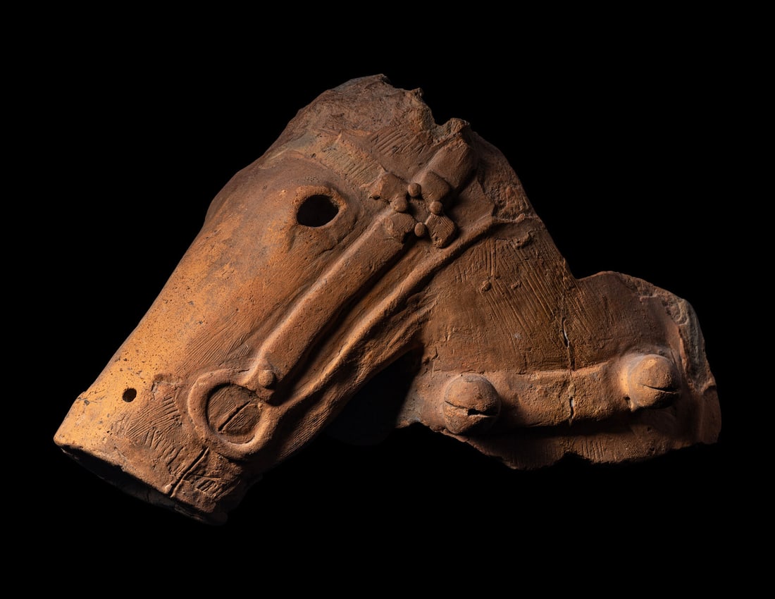 A Japanese Earthenware Fragment of a Head of a Horse: A Japanese Earthenware Fragment of a Head of a Horse Late Kofun Period, 6th/7th Century of low-fired reddish clay, modeled as a head of a horse wearing an elaborate bridle, eyes and mouth pierced. Len