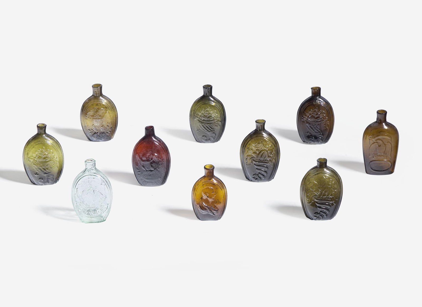 A collection of ten mold-blown colored glass flasks, various makers, 19th century: A collection of ten mold-blown colored glass flasks, various makers, 19th century Comprising example by various makers including Westford Glass Co., Westford, Connecticut; depicting various Patriotic