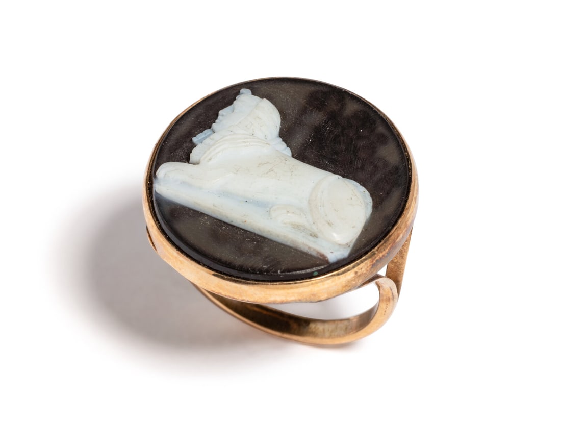 A Neoclassical Gold and Onyx Cameo Ring with a Sphinx: A Neoclassical Gold and Onyx Cameo Ring with a Sphinx Ring size 8 1/4; Length 1 inch (2.54 cm); 14 karat gold; 3.68 dwt. Provenance: Private Collection (1926-2019), Chicago, formed in the 1970s-2000s.