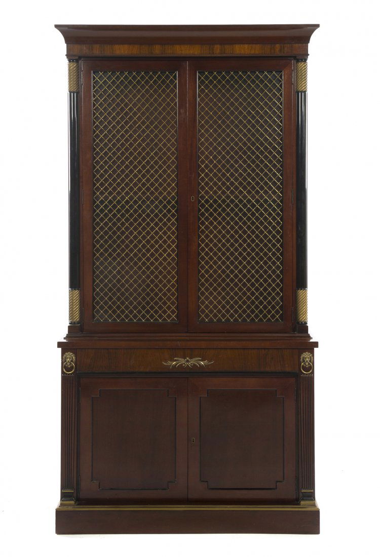 A French Empire Style Mahogany Bibliotheque, Kitti: A French Empire Style Mahogany Bibliotheque, Kittinger, in two parts, the superstructure having two grill inset doors flanked by parcel gilt and ebonized columns opening to a shelved interior, the bas