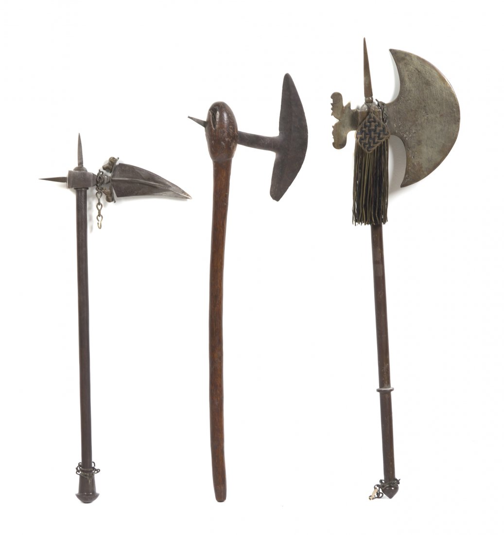 A Collection of Three Weapons, Length of longest 2: A Collection of Three Weapons, comprising a continental military pick and battle ax each with steel shaft, together with a primitive wood ax with wood shaft. Length of longest 29 3/4 inches. Property 