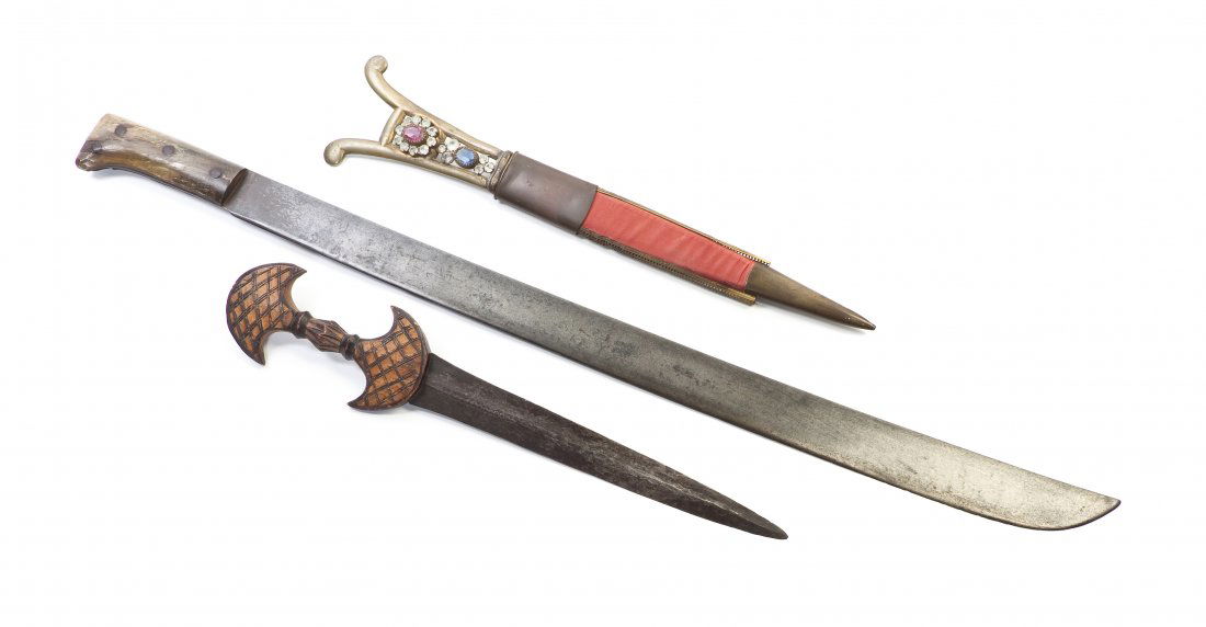 Two Eastern Daggers, Length of longest 31 inches.: Two Eastern Daggers, each having a triangular blade one with glass inset wood handle, the other carved wood handle, together with a machete. Length of longest 31 inches. Property from the Estate of Mr