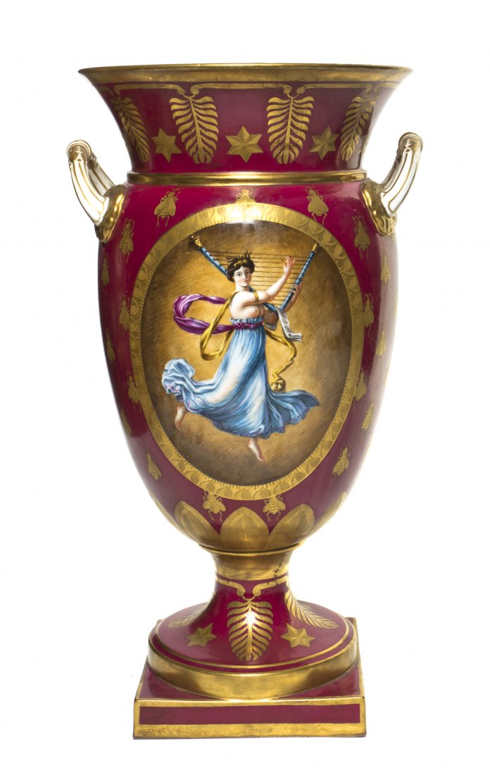A Sevres Style Porcelain Urn, Height overall 15 1/: A Sevres Style Porcelain Urn, of baluster handled form, depicting a lady playing a stringed instrument, with allover bee decoration on a red ground, having M. Imp de Sevres mark to base. Height overal