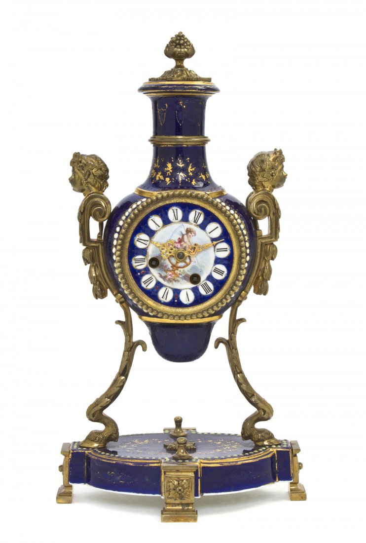 A Sevres Style Porcelain and Gilt Bronze Mounted M: A Sevres Style Porcelain and Gilt Bronze Mounted Mantel Clock, second half 19th century, the bottle form clock having a painted circular dial with Roman numerals raised on monoped supports headed by B