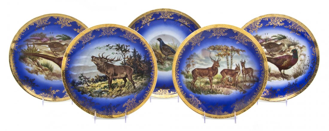 A Set of Five Bavarian Porcelain Game Plates, Diam: A Set of Five Bavarian Porcelain Game Plates, each depicting game animals in a landscape on a cobalt ground with gilt floral borders. Diameter of largest 12 inches.