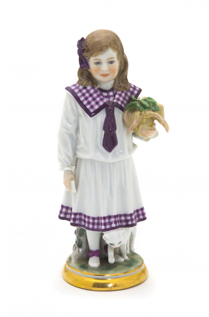 A Meissen Porcelain Figure of a Girl, Height 7 7/8: A Meissen Porcelain Figure of a Girl, depicting a standing figure holding a plant and having a kitten at her feet, raised on a circular base, having crossed swords mark in underglaze blue, incised D22