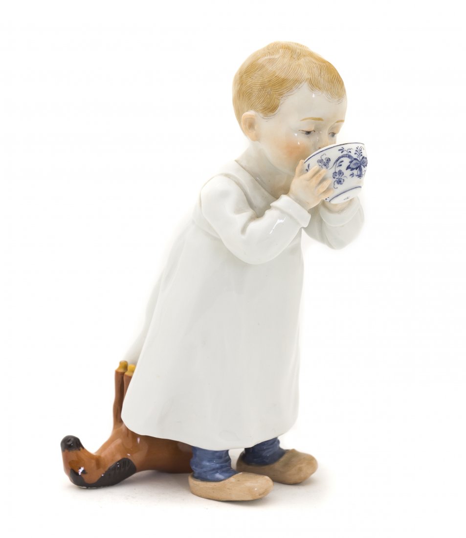 A Meissen Porcelain Figure, Konrad Hentschel (1872: A Meissen Porcelain Figure, Konrad Hentschel (1872-1907), early 20th century, depicting a boy drinking from a Blue Onion pattern cup, a toy horse at his feet, having crossed swords mark in underglaze