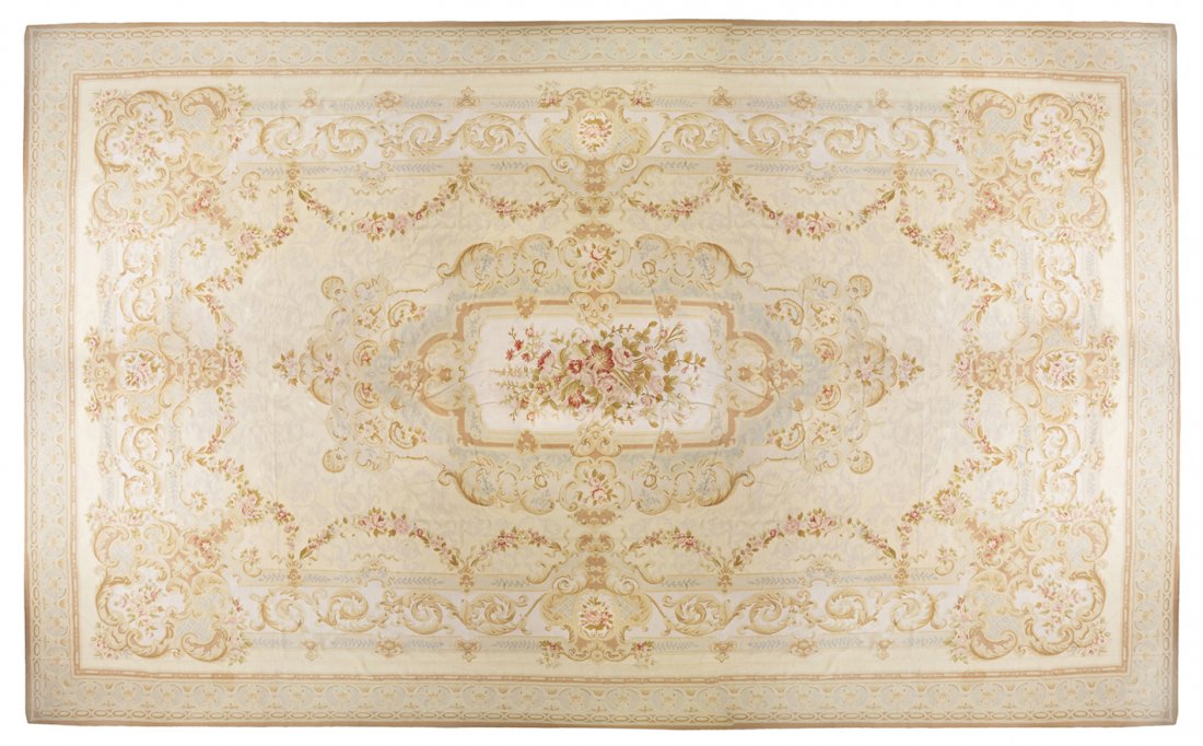 An Aubusson Style Wool Rug, 25 feet x 17 feet.: An Aubusson Style Wool Rug, centered with a spray of flowers on an ivory reserve with a continuous band of ribbon-tied floral festoons, further bordered by scrolling acanthus leaves with foliate carto