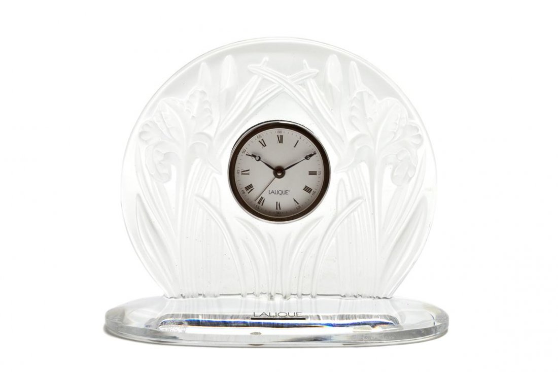 A Lalique Molded and Frosted Glass Table Clock, H: A Lalique Molded and Frosted Glass Table Clock, Iris, with quartz movement, having etched Lalique R France signature, with original box. Height 6 1/2 x width 7 3/4 inches.