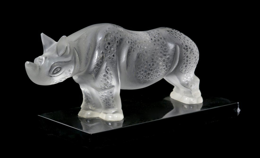 A Lalique Molded and Frosted Glass Sculpture, Len: A Lalique Molded and Frosted Glass Sculpture, depicting a rhinoceros, set on a black plinth base, signed Lalique R. France. Length overall 11 1/2 inches. Property from the Ethel Miller Siegel Trust, B
