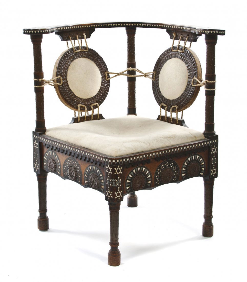 A Carlo Bugatti Walnut Corner Chair, Height 28 in: A Carlo Bugatti Walnut Corner Chair, with a curved crest rail above three stiles and two circular splats suspended with over a square seat, inlaid throughout with bone, brass and pewter. Height 28 inc