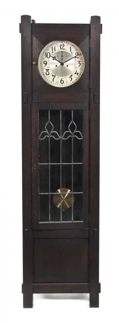 An American Arts and Crafts Oak Tall Case Clock, : An American Arts and Crafts Oak Tall Case Clock, in the manner of Stickley, having a circular dial with Arabic numerals and a secondary dial with Arabic numerals at quarter hour increments, the case w