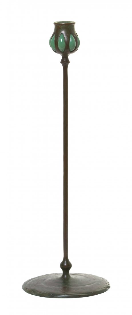 A Tiffany Studios Patinated Bronze and Favrile Gl: A Tiffany Studios Patinated Bronze and Favrile Glass Candlestick, having a bulbous candle cup with blown out green glass, above the slender standard, raised on a circular base, stamped 2184, Tiffany S