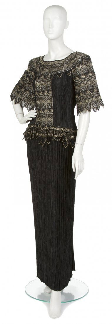 A Mary McFadden Black Fortuny Pleat Gown,: A Mary McFadden Black Fortuny Pleat Gown, black lace and lurex sleeves and embellishment at bodice and hips. Labeled: Mary McFadden / Sara Fredericks.